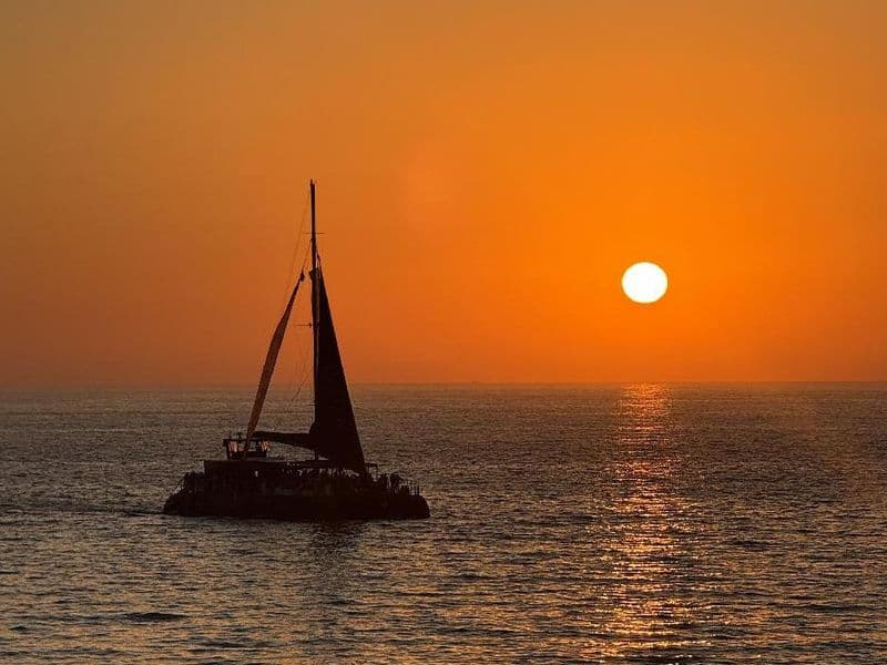 Puesta de sol desde el puerto de Cádiz con copa de cava