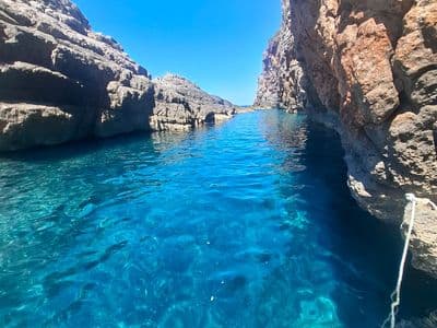 Narrow rocky channel with crystal-clear blue water
