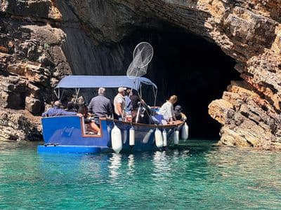 Boat sailing into a sea cave on the Budva coast