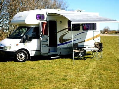 Ford Transit motorhome White Arrow with extended awning and camping chairs
