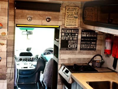 Kitchen inside Mercedes Sprinter campervan GI Joe with sink and fire extinguisher