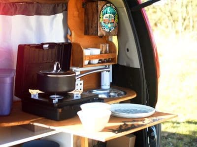 Rear kitchen of Bluey with portable gas stove, crockery and sink