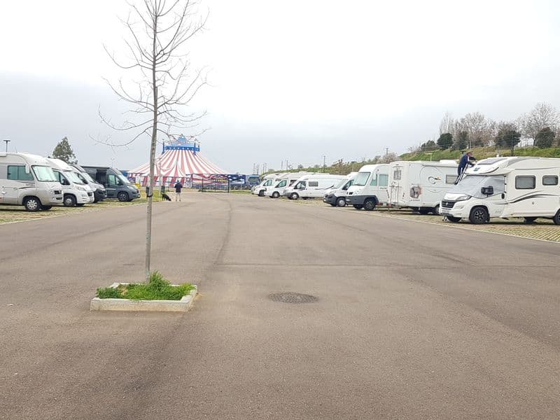Motorhomes parked in a row at the área de autocaravanas in Mérida, Spain
