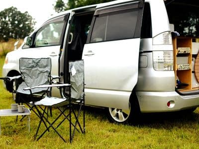 Toyota Voxy sleepervan with open doors, rear kitchen and camping chairs