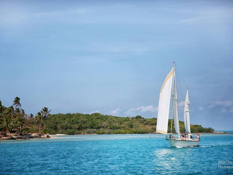 Sailing yacht in front of a tropical island on a day charter from Koh Samui