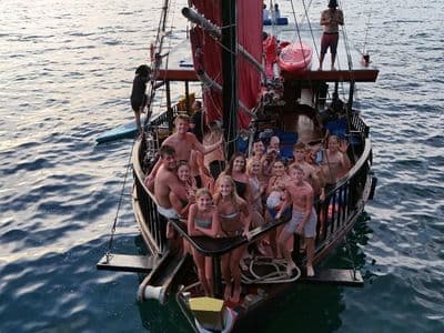 Wooden junk boat of Krabi Sunset Cruises sailing among the Andaman Sea islands