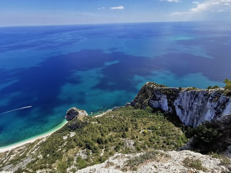 Pogled s litica Monte Conera na tirkizno more i plažu kod Sirola