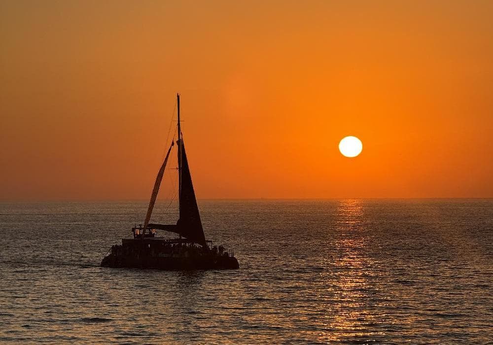 Puesta de sol desde el puerto de Cádiz con copa de cava