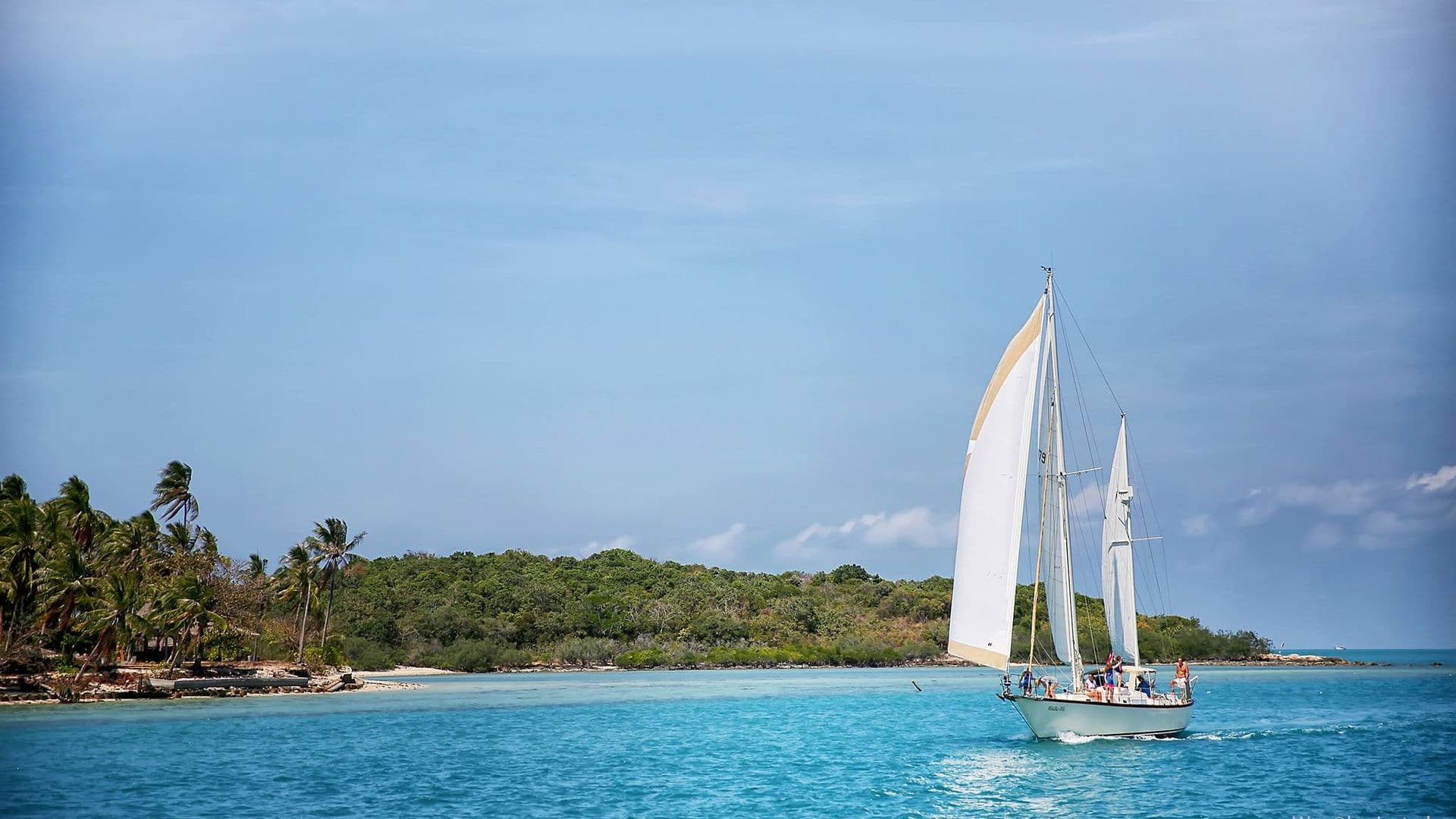 Sailing yacht in front of a tropical island on a day charter from Koh Samui